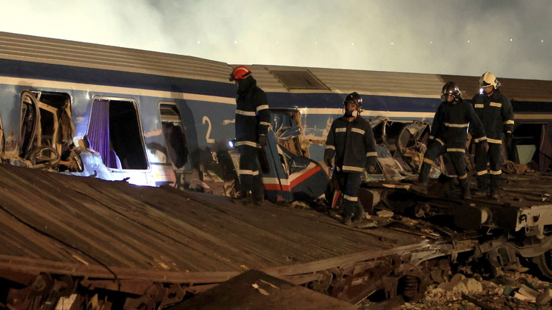 Feuerwehrleute arbeiten nach einer Kollision zweier Züge am Ort des Zusammenstoßes eines Güterzugs mit einem Personenzug.