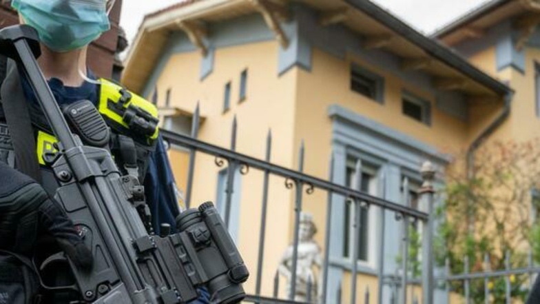 Schwer bewaffnete Polizisten stehen vor der Remmo-Villa im Berliner Stadtteil Alt-Buckow.