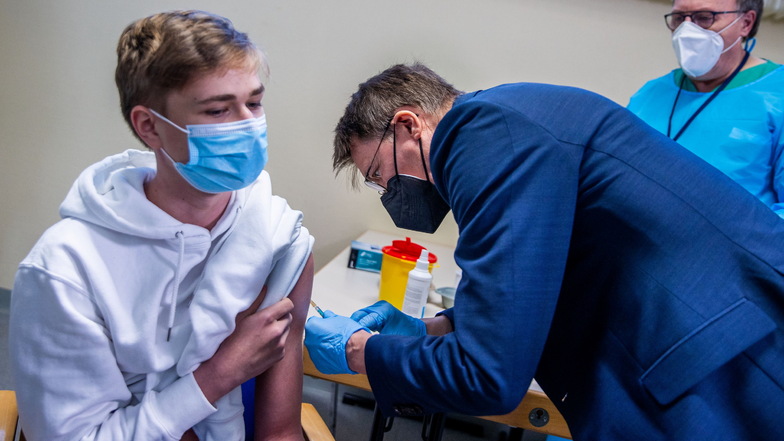 Bundesgesundheitsminister Karl Lauterbach (SPD), setzt in einem Impfzentrum eine Spritze.