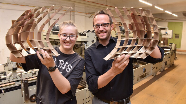 Wer schafft es wie schnell, diese Gebilde zusammenzustecken? Ronny Ruider und Azubi Lauren Wöller von der Glashütter Pappen- und Kartonagenfabrik laden am Sonnabend in Pirna dazu ein, es zu probieren.