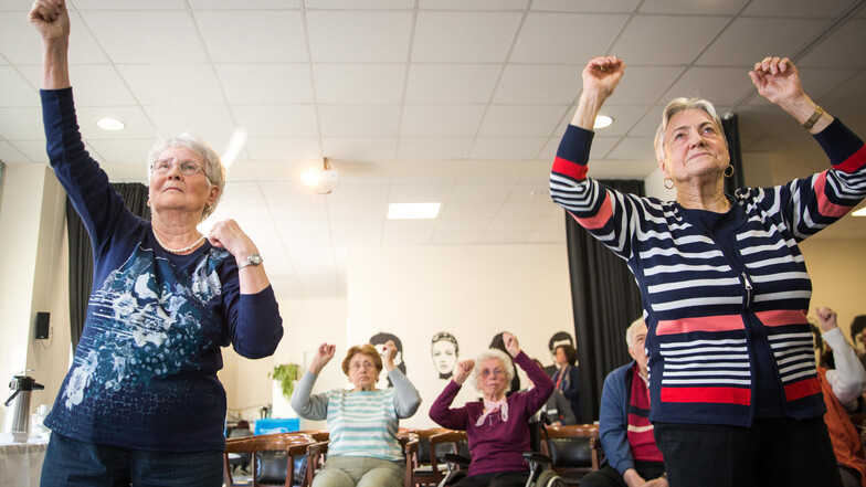 Arme hoch und los: Jutta Hauser (l.) und Roswitha Richter probierten sich am Freitag in der Alexa Seniorenresidenz Dresden im Tanzen – per Videospiel. Andere Bewohner ließen sich vom Rhythmus anstecken.