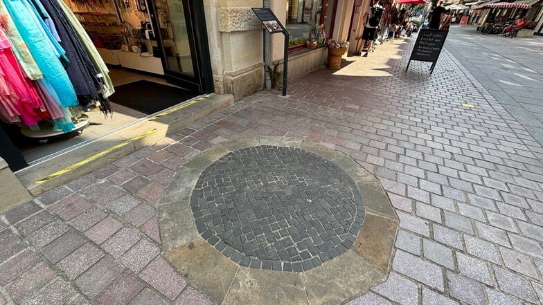 Markierter Brunnen auf der Dohnaischen Straße: Ein andersfarbiger Steinring nebst Erklärtafel erinnert an den Wasserspeicher.