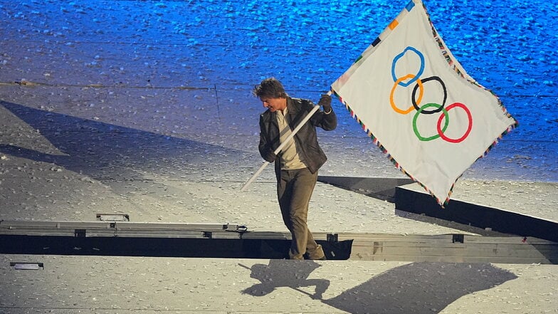 US-Schauspieler Tom Cruise hält während der Schlussfeier die olympische Fahne.