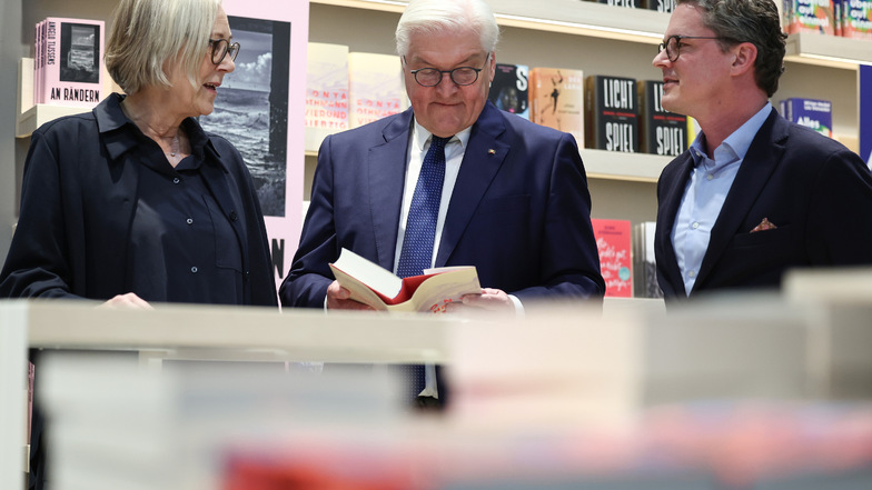 Bundespräsident Frank-Walter Steinmeier (mitte) schaut bei seinem Besuch der Leipziger Buchmesse neben Nicola Bartels, Verlegerische Geschäftsführerin, und Christian Jünger, Kaufmännischer Geschäftsführer, in ein Buch.