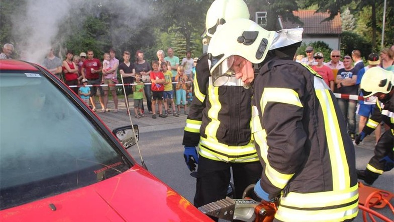Die Feuerwehr zeigte ihr Könnnen, zum Beispiel wie man bei einem brennenden Auto reagiert.   Ein Hydraulik -Spreizer kommt zum Einsatz.