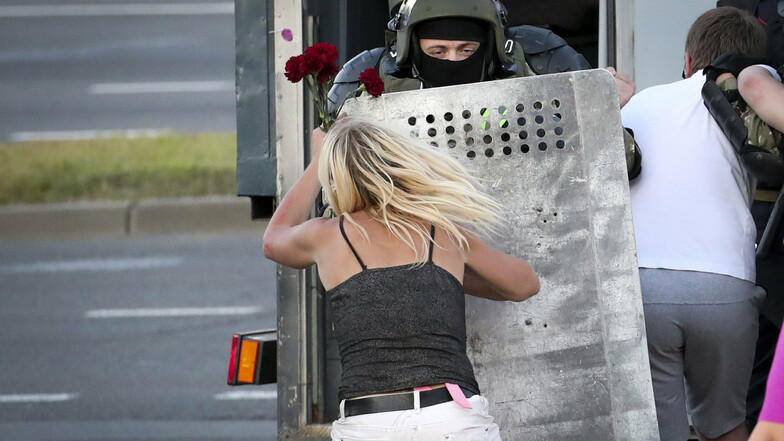 Eine Frau schubst einen Polizisten, nachdem viele Demonstranten festgenommen worden sind.