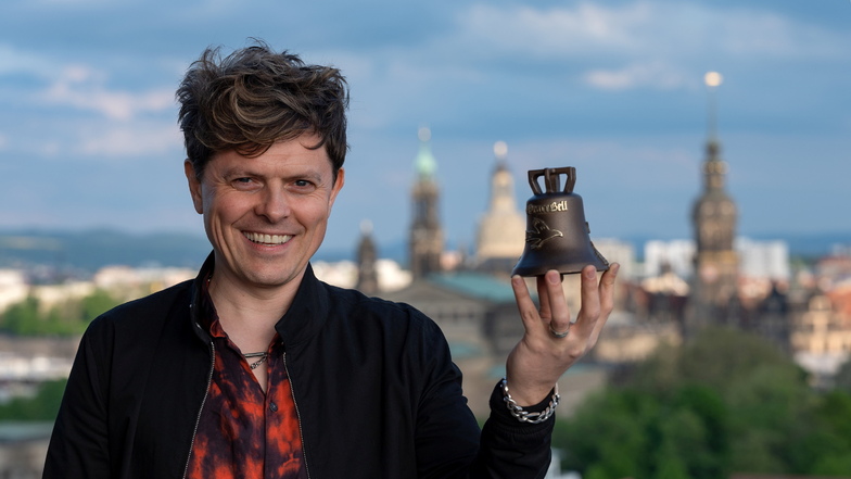 Michael Patrick Kelly präsentiert auf dem Dach des Dresdner Hauses der Presse die neue Dresden-Edition seiner kleinen Peace Bell. Das Logo der Frauenkirche ziert die kleine Glock, die ab sofort in den DDV Lokalen und online zu bestellen ist.