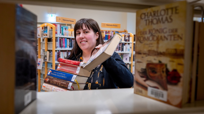 Madlin Fricke , Fachangestellte für Medien- und Informationsdienst, hat in der Stadtbibliothek einen Stapel Bücher in den Händen. Das gedruckte Buch ist in der Lesergunst trotz alternativer Angebote immer noch weit vorne.