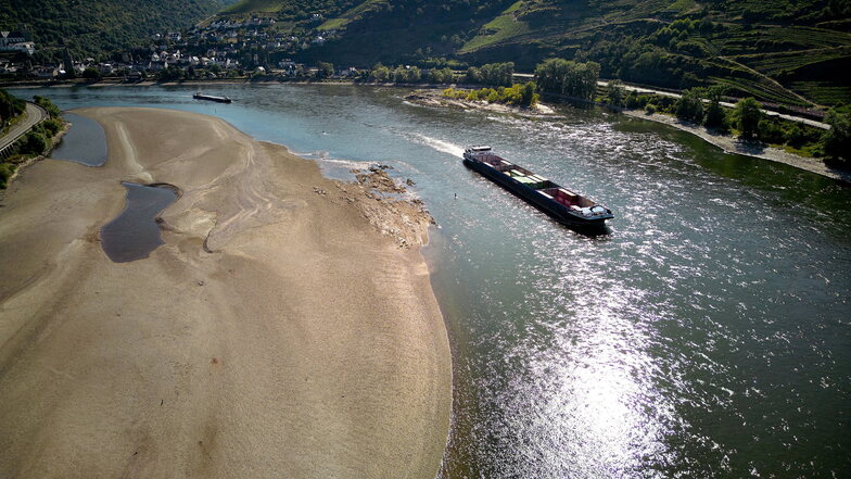 Ein Frachtschiff passiert auf dem Rhein eine Sandbank. Durch die anhaltenden Trockenheit des Hochsommers fällt der Wasserspiegel des Mittelrheins immer weiter.