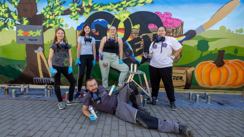 Frieda, Lena, Theresa und Vanessa (v.l.) haben mit Kamil Kubis ein großes Graffito gesprüht - um darzustellen, was für sie zu einem guten Leben zählt.