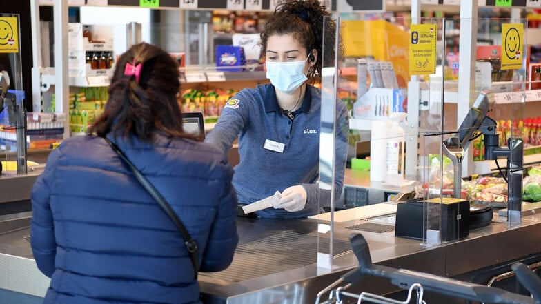 Supermärkte haben Plexiglas als Spuckschutz installiert, um Tröpfchen von Kunden abzufangen.