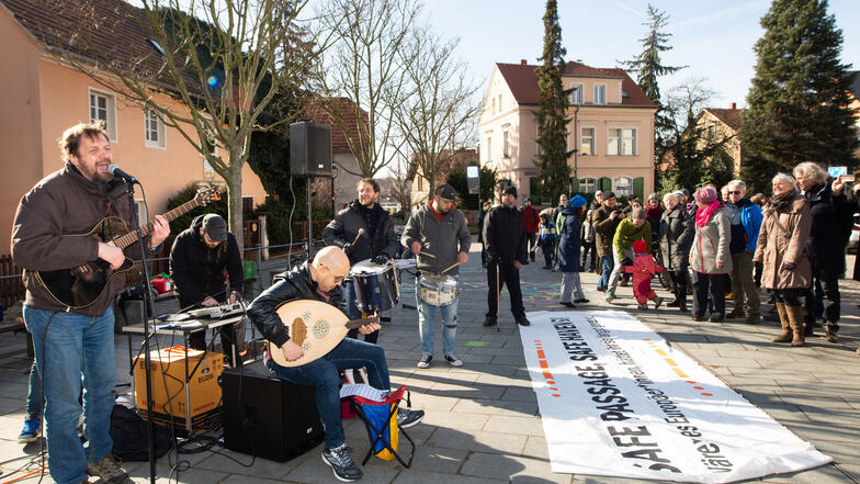 Das Banner zu Füßen der Musiker und Besucher fordert eine sichere Passage für Flüchtlinge übers Mittelmeer.
