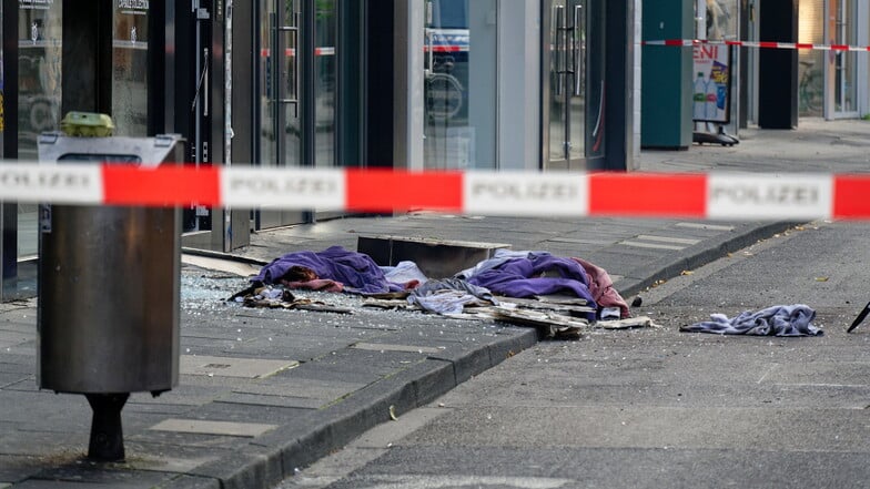 Scherben und Kleidungstücke liegen vor einem Geschäft in der Ehrenstraße in Köln.