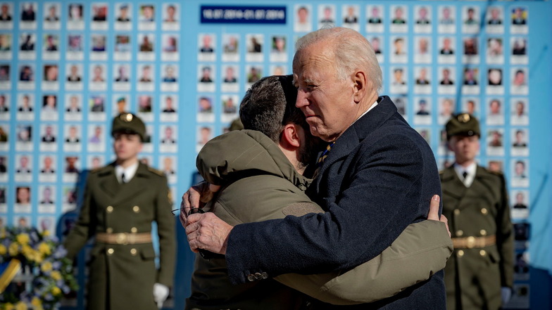 Biden (Mitte r) und Selenskyj umarmen sich zum Abschied an der Gedenkmauer für die gefallenen Verteidiger der Ukraine.
