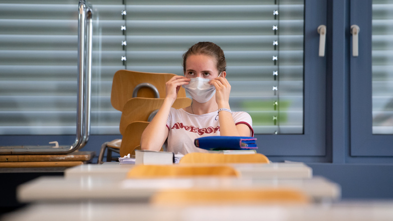 Eine Schülerin rückt im Klassenzimmer ihren Mund-Nasen-Schutz zurecht. Auch in der Döbelner Region werden ab dieser Woche wieder mehr Kinder und Jugendliche die Schulen besuchen.