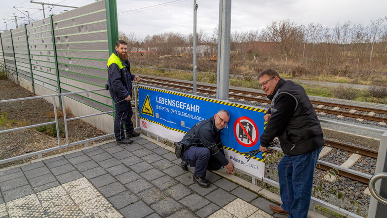 Am Bahnhof Niesky wurde am Montag durch die Präventionsbeauftragten von Deutscher Bahn, Bundespolizei und Stadt Niesky (von links) ein neues Banner angebracht, das auf die Gefahren auf Bahnanlagen hinweist.