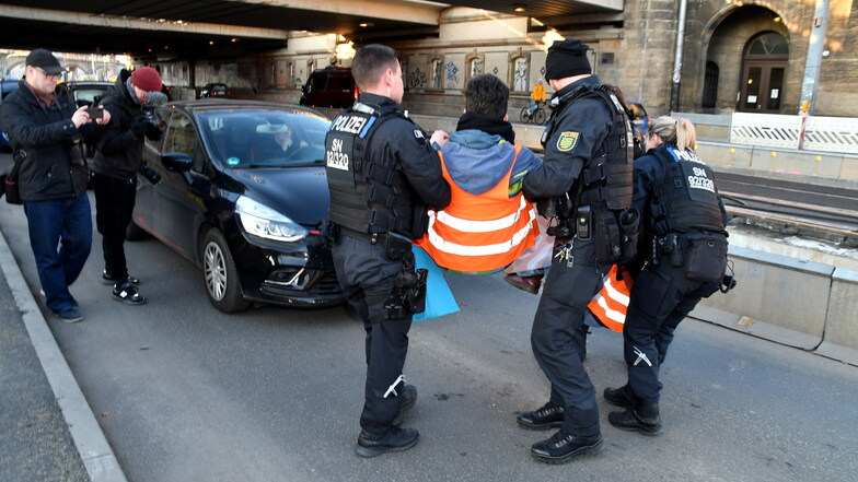 Klimademonstranten von "Letzte Generation" blockierten am Mittwochnachmittag eine Straße am Bahnhof Dresden-Neustadt, wurden aber nach wenigen Minuten von Polizisten weggetragen.