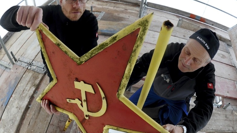 Sven Baron (li.) und Gunter Bollfraß von Baron Bau Trebendorf bauen den Stern ab, um das internationale Symbol der Arbeiterbewegung aufzuarbeiten.