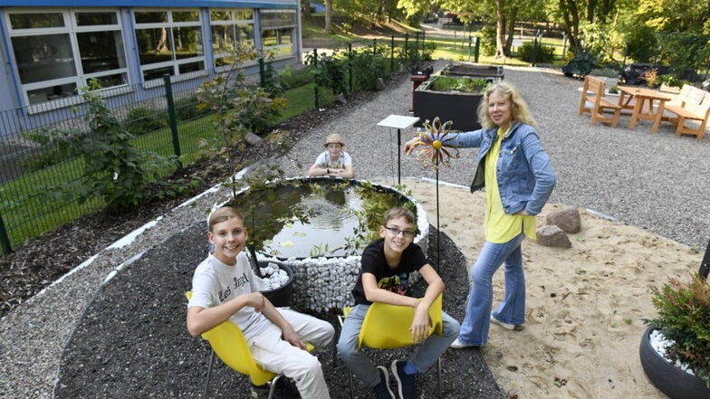 Lehrerin Sylke Jaroslawsky und ihre  Schüler Felix (re.), Julius und Sven (hinten) pflegen gerne das "Grüne Klassenzimmer".