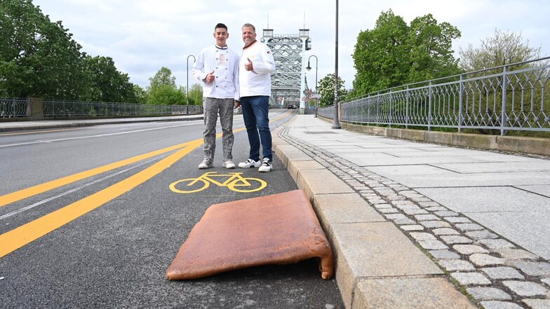 Die Bäckermeister René Krause (re.) und Juan Rüdrich haben für den neuen Radweg auf dem Blauen Wunder - ein Verkehrsversuch - eine Rampe gebacken und am Montagvormittag aufgestellt.