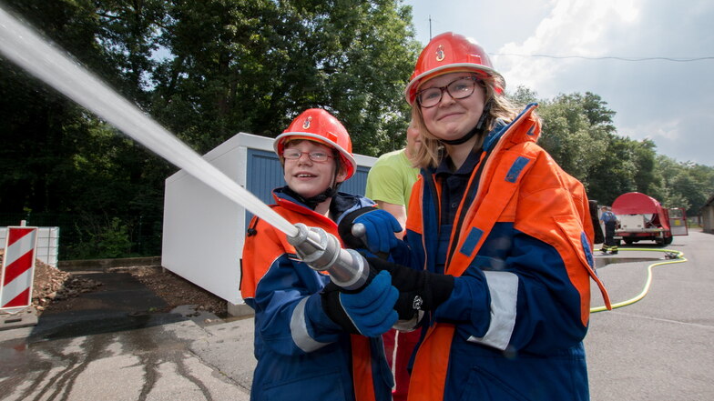 Lena und Katharina von der Jugendfeuerwehr testen die neue Tragkraftspritze.