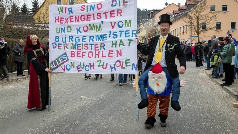 Bürgermeister Thomas Mutze (parteilos) trägt ein Plakat, das ihn selbst auf die Schippe nimmt.