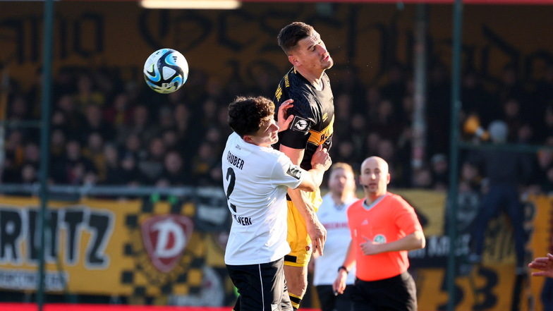 Mit dem Kopf leitet Dynamo-Kapitän Stefan Kutschke einen Ball im Duell mit Fabio Gruber auf einen Mitspieler weiter.