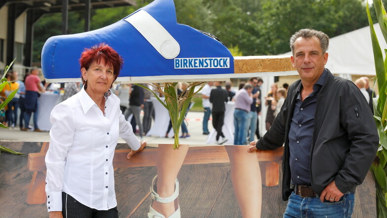Große Schuh-Pläne bei Birkenstock in Bernstadt: Betriebsratsvorsitzende Ramona Kühnel (links) und der geschäftsführende Werksleiter Andreas Schulz vor einem riesigen Birkenstock Clock.