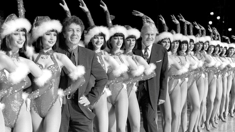 1998, Berlin: Michael Schanze (vorn) und Gunther Emmerlich stehen während der Generalprobe als Moderatoren der Weihnachtsrevue "Jingle Bells" im Friedrichstadtpalast zwischen Ballett-Tänzerinnen.