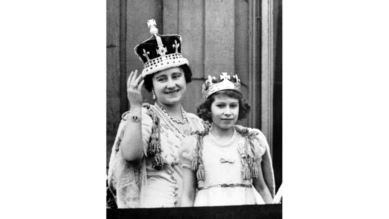 1937 winken Königin Elizabeth und ihre älteste Tochter Prinzessin Elizabeth, spätere Königin Elizabeth II., nach der feierlichen Krönung von George VI. vom Balkon des Buckingham-Palastes der Bevölkerung zu.