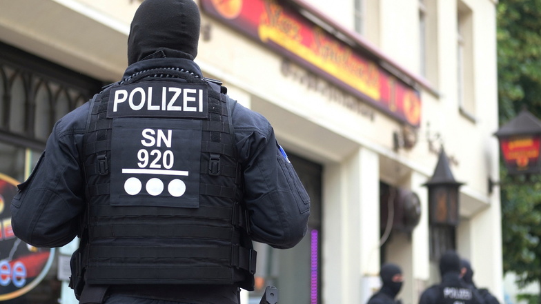 Polizisten stehen vor einem Cafe in der Leipziger Eisenbahnstraße. Dort fand am Donnerstag eine Razzia des Hauptzollamtes statt.