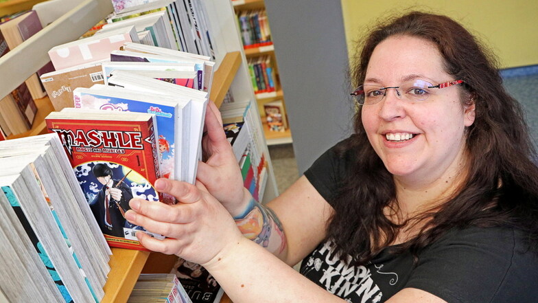Mitarbeiterin Julia Schunk zeigt neue Mangas in der Stadtbibliothek.