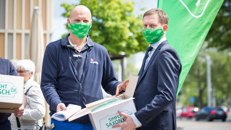 Als Dankeschön gab es von Ministerpräsident Michael Kretschmer (CDU, r.) Mund-Nase-Masken für die Mitarbeiter von Peter Simmel. Der Besuch war Teil der Werbeaktion "So geht sächsisch".