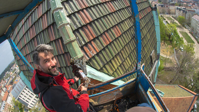 Danilo Mittrach repariert in luftiger Höhe das Dach der Lutherkirche.