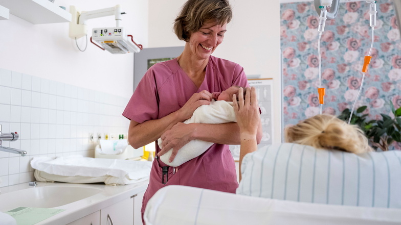 Im Kreißsaal der Muldentalkliniken in Grimma kümmert sich Mandy Wendrich, Leiterin des freiberuflichen Hebammen-Teams am Krankenhaus, um ein Neugeborenes.