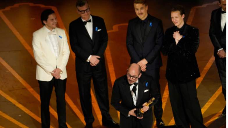Regisseur Edward Berger (vorne) nimmt den Oscar für «Im Westen nichts Neues» entgegen. Hinten stehen die Schauspieler Daniel Brühl (l-r), Malte Grunert, Albrecht Schuch und Felix Kammerer.