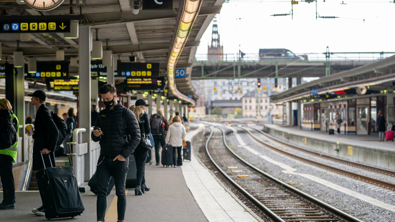 Seltener Anblick: Ein Mann mit Mund-Nasen-Schutz wartet am Bahnsteig auf das Einfahren eines Zuges in Stockholm.