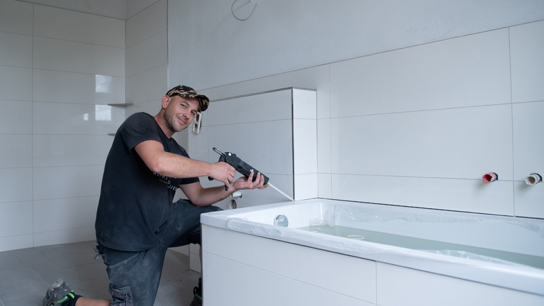Markus Mende beim Verfugen der Fliesen im Bad der ersten sanierten Wohnung, die im September in Kalkreuth bezogen wird.