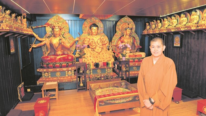 Thich Tong Chu steht vor den prächtigen Figuren in einem Raum des buddhistischen Kloster Amitayus in Schönfeld.