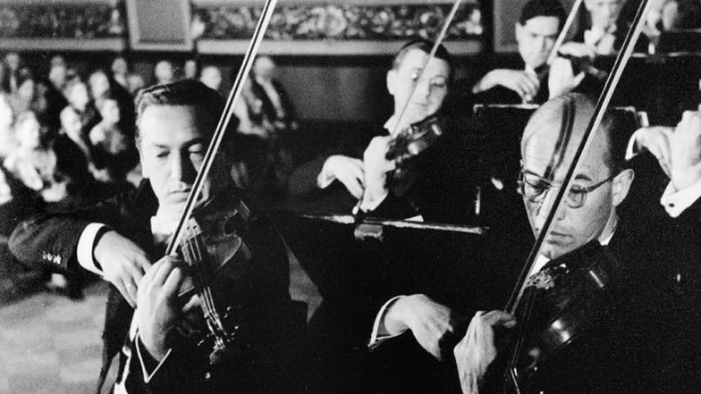 Die Dresdner Philharmonie spielt im NS-Propagandafilm „Symphonie eines Lebens“ (1942) in der alten Berliner Philharmonie mit: Erster Konzertmeister Bernhard Hamann (l.) und Konzertmeister Arthur von Freymann.