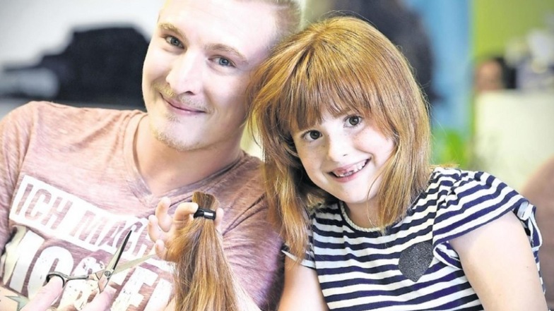 Emma und Friseur Daniel Drescher im Sommer 2017. Die damals Sechsjährige hatte ihre Haare gespendet.
