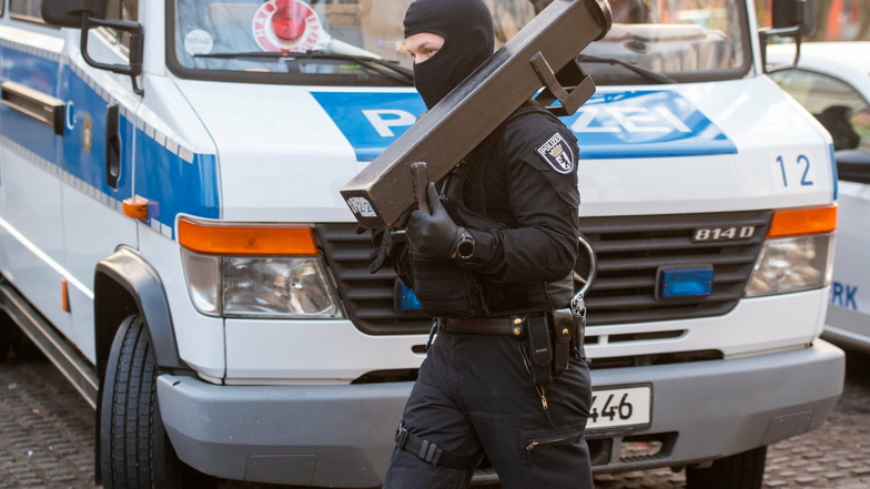 Ein Polizist mit einer Ramme: In einer großangelegten Razzia gingen Beamte gegen eine islamistische Vereinigung vor.
