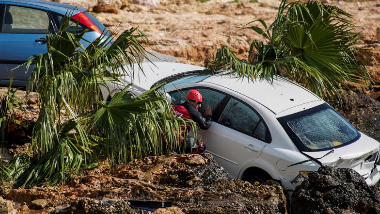 Ein Feuerwehrmann überprüft ein Auto, das in Alcanar festsitzt. Der größte Teil des spanischen Festlandes ist wegen starker Regenfälle in Alarmbereitschaft.