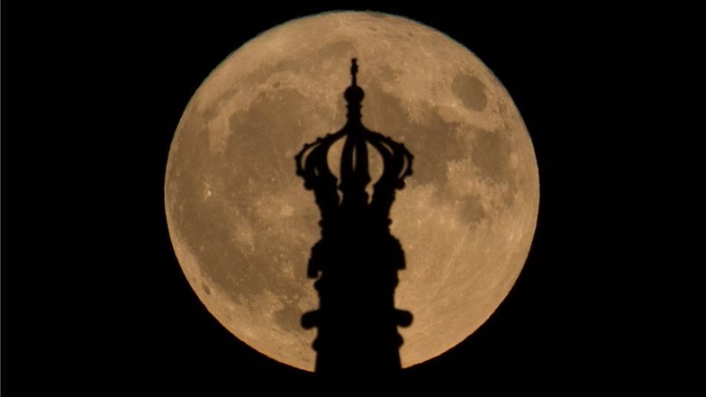 Wenn die Lichter pausieren, zeigt der Mond seine Strahlkraft - wie hier hinter der Krone der Staatskanzlei.