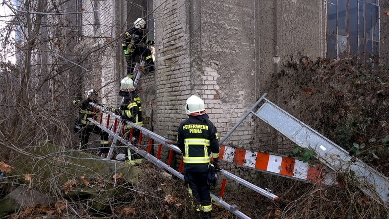 Komplizierter Einstieg: Feuerwehrleute erklimmen über Steckleitern die Wand bis zu den Fenstern.