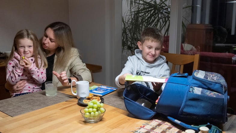 Viktoria Martsenko zu Hause in Dresden-Pappritz mit ihren Kindern Diana und Jan. Ihr Sohn hat gerade die Hausaufgaben fertig gemacht.