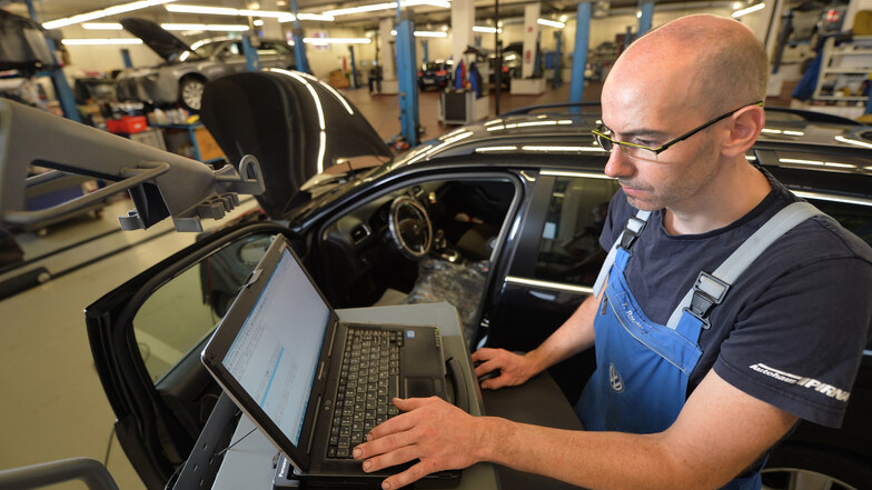 In einem Autohaus führt ein Mitarbeiter ein Software-Update für einen VW-Diesel durch. Ob diese Lösung ausreicht, um den Mangel der durch die Betrugssoftware verschleierten, zu hohen Abgaswerte zu beheben, ist allerdings umstritten.