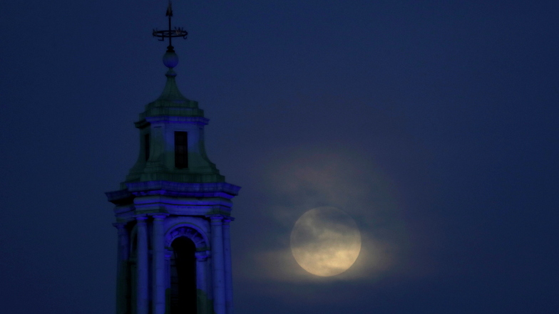 Der Mond geht durch die Wolken über der County Hall in London auf.
