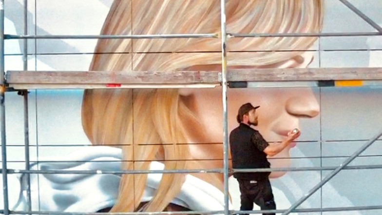 Graffiti-Künstler Dirk Hiekel bei der Arbeit am Antlitz der jungen Frau auf dem größten Cottbuser Wandbild in der Sanzebergstraße 12 im Stadtteil Sandow.