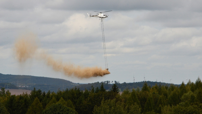 Was rieselt denn da vom Himmel? Ein Hubschrauber verteilt Kalk über einem Waldstück.